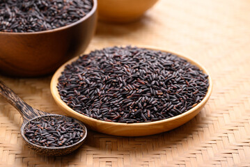 Organic rice berry or purple rice on wooden plate with spoon, Thai rice