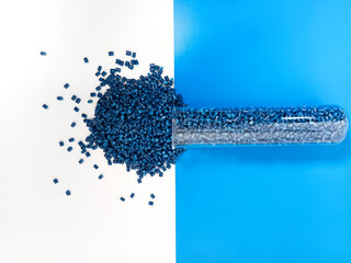 Blue masterbatch granules are poured into a white and blue background medium, the polymer carries...