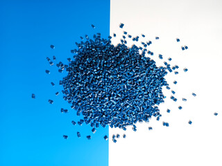 Blue masterbatch granules are poured into a white and blue background medium, the polymer carries...