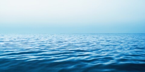 Fototapeta premium Tranquil Scene of Deep Blue Water with Ripple Patterns Under Light Blue Sky, Creating Peaceful Serenity on Horizon.