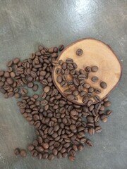 A stylish arrangement of roasted coffee beans with a wooden slice on a rustic surface. Perfect for coffee culture, food photography, or branding purposes in beverage industries.