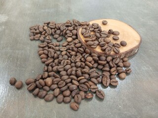 A stylish arrangement of roasted coffee beans with a wooden slice on a rustic surface. Perfect for coffee culture, food photography, or branding purposes in beverage industries.