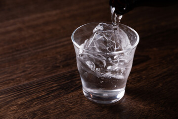 グラスに焼酎を注ぐ