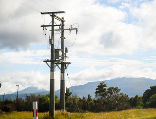Transformer of an electrical post along the motorway. Mountains in the background. North Island....