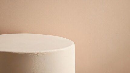White Cylindrical Display Against Beige Background