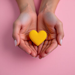 Obraz premium Symbolic image of hands gently holding a 3D yellow heart on a soft pastel pink background, representing mental health awareness, compassion, and emotional support.