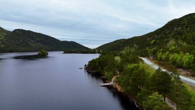 Aerial view of a road adjacent Bolg Vand lake (Bolgvatnet) on a cloudy day in Kristiansund, Norway