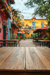Fototapeta premium This Cinco de Mayo-inspired outdoor space features a wooden table in the foreground, surrounded by colorful decor and festive lighting