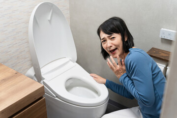 トイレのトラブルで困るミドル女性　ライフスタイルイメージ
