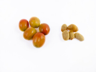 a group of ripe coffee berries and coffee that has been peeled