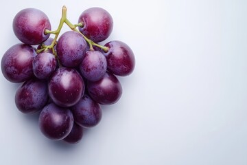 A cluster of fresh grapes is elegantly arranged on a wooden table, showcasing their vibrant color and natural beauty.