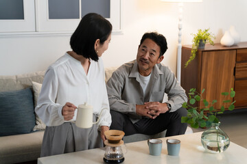 ミドル男性さんにコーヒーを淹れるミドル女性　ライフスタイルイメージ