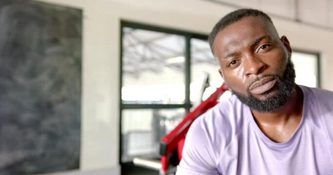 Sweating and resting, african american man in gym after intense workout session, copy space