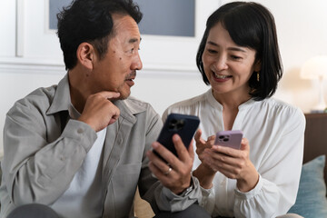 スマートフォンで調べものをするミドル夫婦　ライフスタイルイメージ