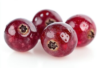 Three vibrant red berries rest elegantly on a clean white surface, showcasing their natural beauty and vivid color contrast.
