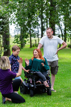 Boy and parents chatting with occupational therapist and speech pathologist outdoors