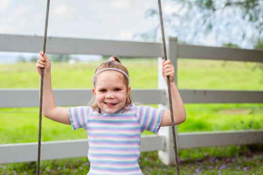 Six year old child swinging on swing in country with genetic condition lymphatic malformation