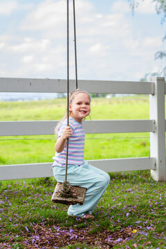 Six year old child swinging on swing in country with genetic condition lymphatic malformation