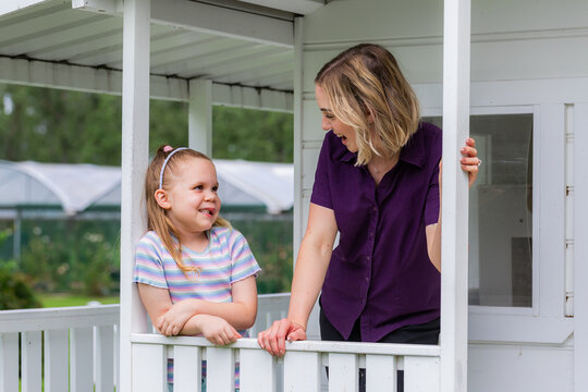 Speech therapist professional with girl interacting by cubby house talking and assessing child