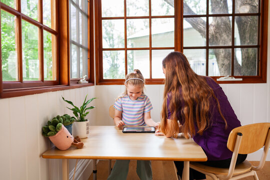 Speech therapist professional with child using technology to help with language development