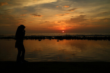 Fototapeta premium Silhouettes of people on the beach at sunset.