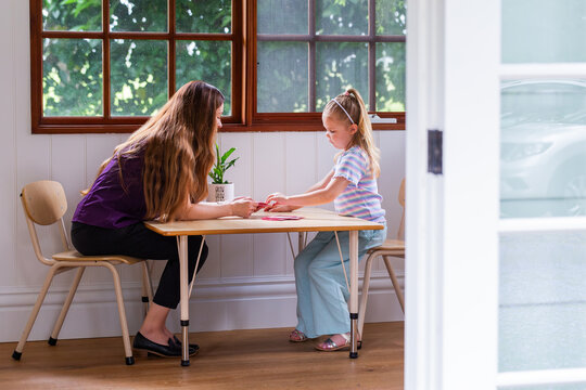 Speech pathologist working with young girl using word flash cards for language development