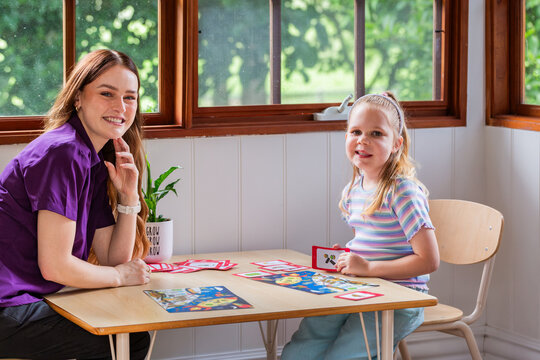 Child with speech disability looking at sound cards talking with speech-language pathologist
