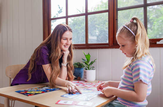 Child with speech disability looking at sound cards talking with speech-language pathologist