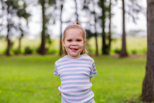 Portrait of happy young girl with genetic condition lymphatic malformation outside in country