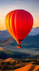 A red hot air balloon floats peacefully over a picturesque landscape at sunset, offering breathtaking mountain views.