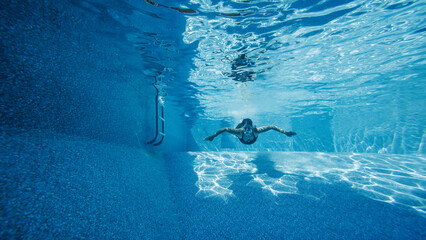 Underwater shot of a women swimming in a pool on a summer day