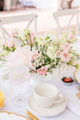 Elegant floral centerpiece with pink and white flowers on table.