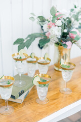 Refreshing lime cocktails in gold-rimmed glasses with floral decor