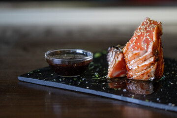 a salmon tataki in a restaurant with sauce
