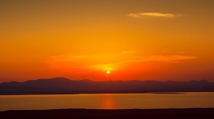 Obraz premium Fiery Sunset Over Mountains and Calm Lake