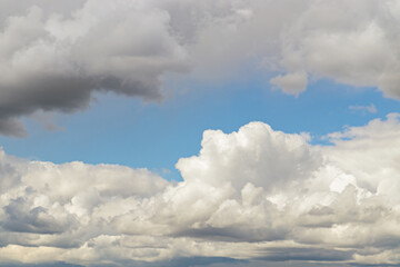 Obraz premium A few light Cumulus and Cirrus clouds in a clear blue sky. summer bright image of the sky.