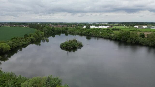 Small lake in agricultural fields during daytime near Sleaford town in Lincolnshire, England, UK