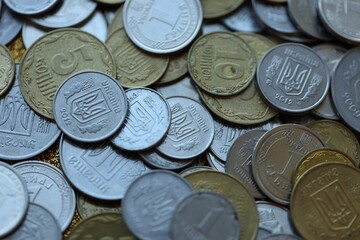 Metal coins of Ukraine of different denominations are scattered. Money texture, business background.