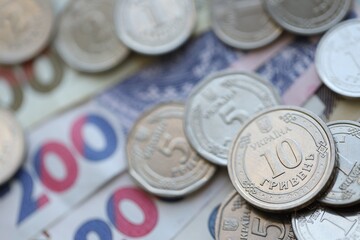 Ukraine money coins lying on mixed hryvnia banknotes. Finance background concept.