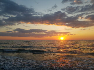Obraz premium A breathtaking sunset over the ocean, captured at the water's edge