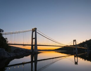 Obraz premium Sunset Serenity: Majestic Suspension Bridge Reflecting in Calm River Waters