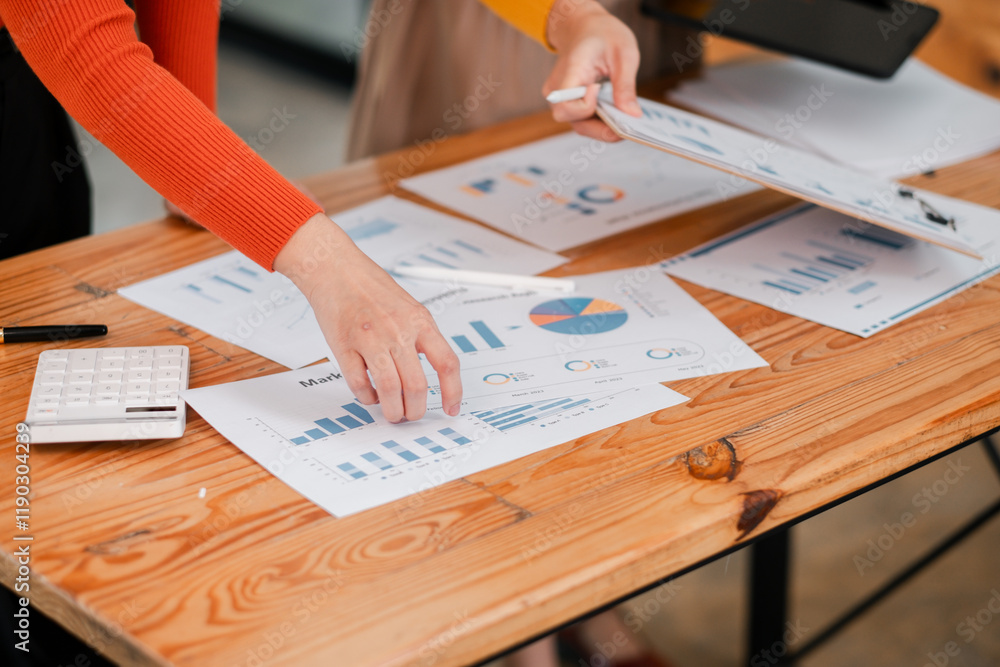 Poster business team analyzing financial data with charts and graphs on wooden desk in modern office settin