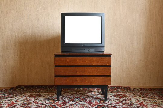 Vintage white screen tv on wooden antique stand, old house design. Sony trinitron kv-21m3.