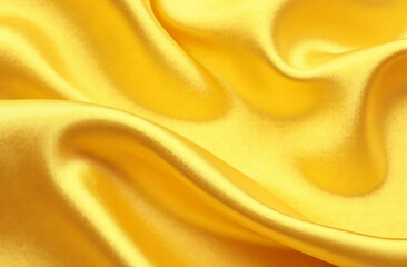 Obraz premium Gold background, satin flying fluttering fabric, smooth fabric with shimmering effect.