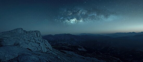 Night sky over mountain range, Milky Way visible.