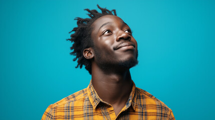 African American creative with joyful expression against blue backdrop. Ideal for artistic professionals, creative industry, or authentic emotion content.