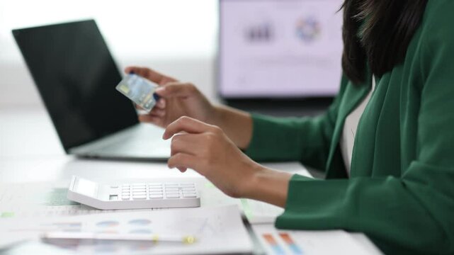 Woman analyzing finances and credit card debt. Stressed businesswoman in office reviewing financial statements, checking credit card balance, and contemplating debt management. Financial planning.