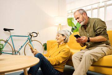 Senior couple using mobile phones and digital tablet at home