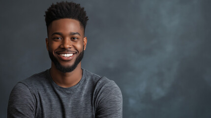 Obraz premium African American man with friendly smile against dark background. Perfect for professional headshots, personal branding, or corporate portraits