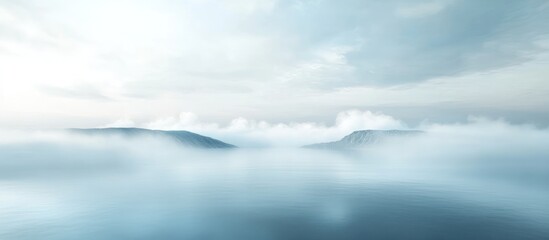 Misty mountain landscape with soft, ethereal light and clouds.